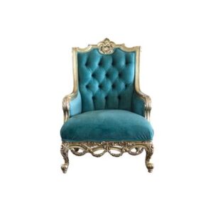 An ornate, antique-style armchair featuring an intricately carved silver-gilded wooden frame with cabriole legs and a decorative crest. The chair is upholstered in rich teal velvet with a high, deep button-tufted backrest, padded armrests, and a plush seat cushion